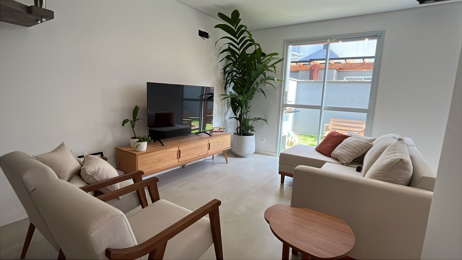 Sala de estar clara com sofá e planta