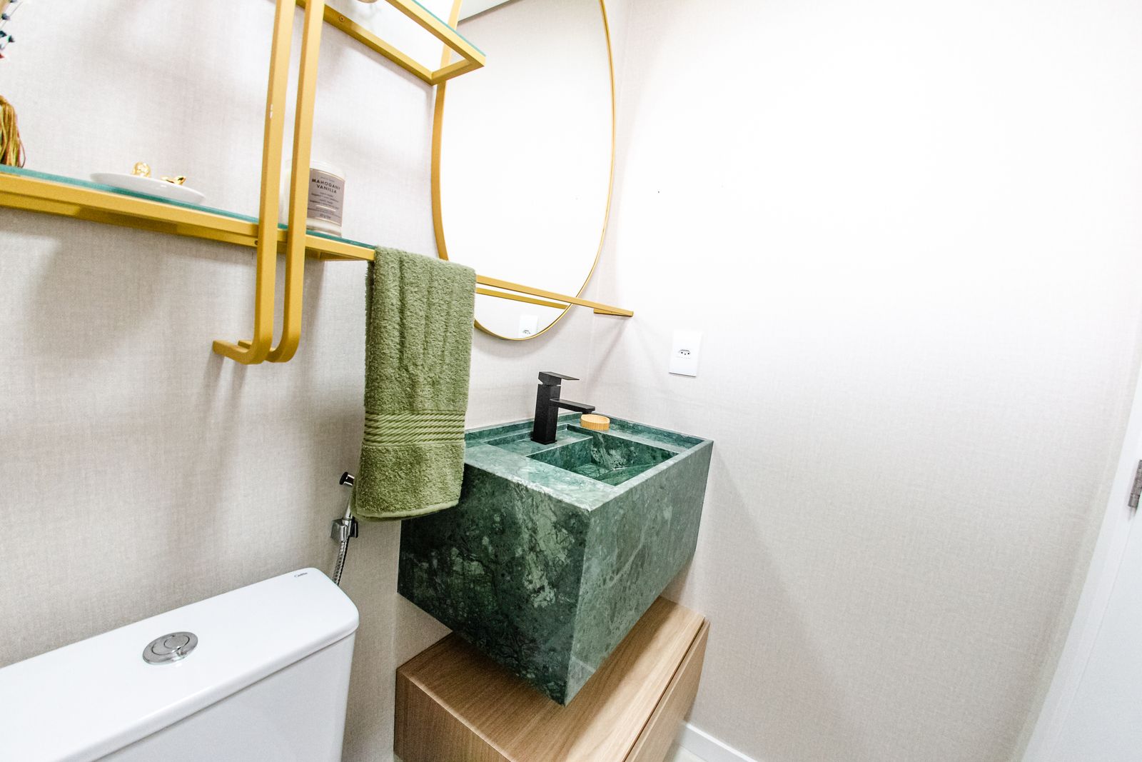 Lavabo com cuba de mármore verde e metais dourados