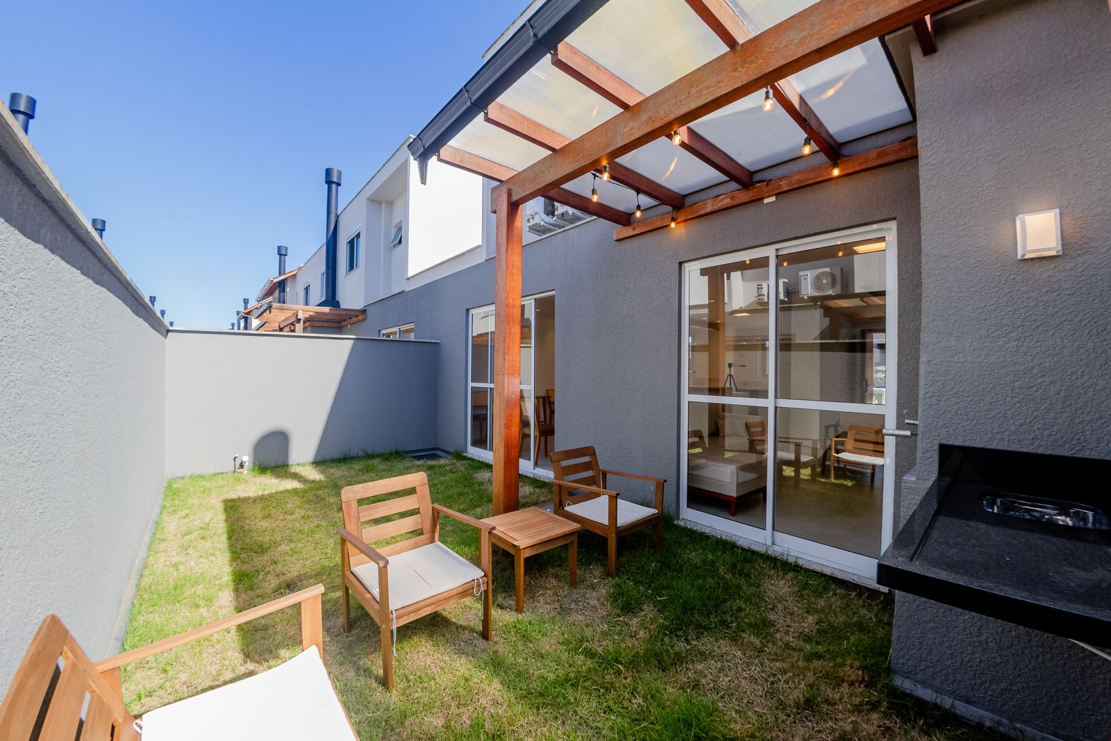 Jardim com pérgola e poltronas
